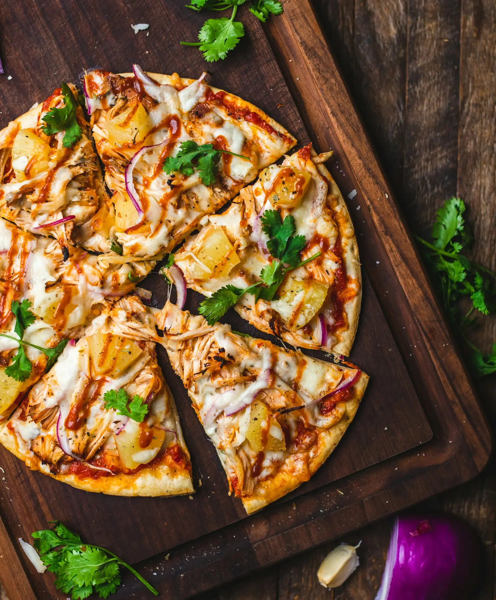 Pizza cortada em fatias sobre uma tábua de madeira, vista de cima