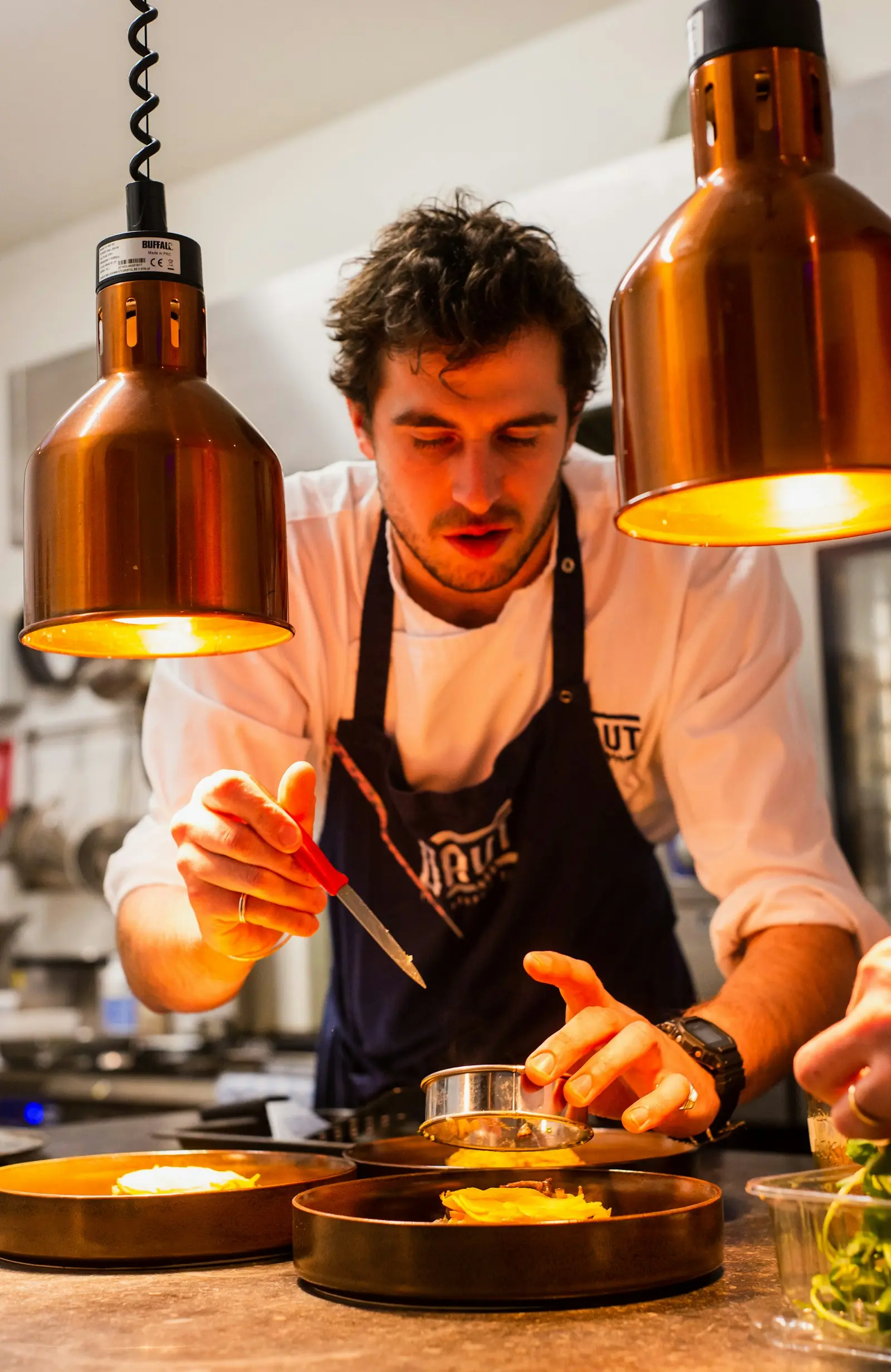 Chef plating dishes on a professional kitchen line